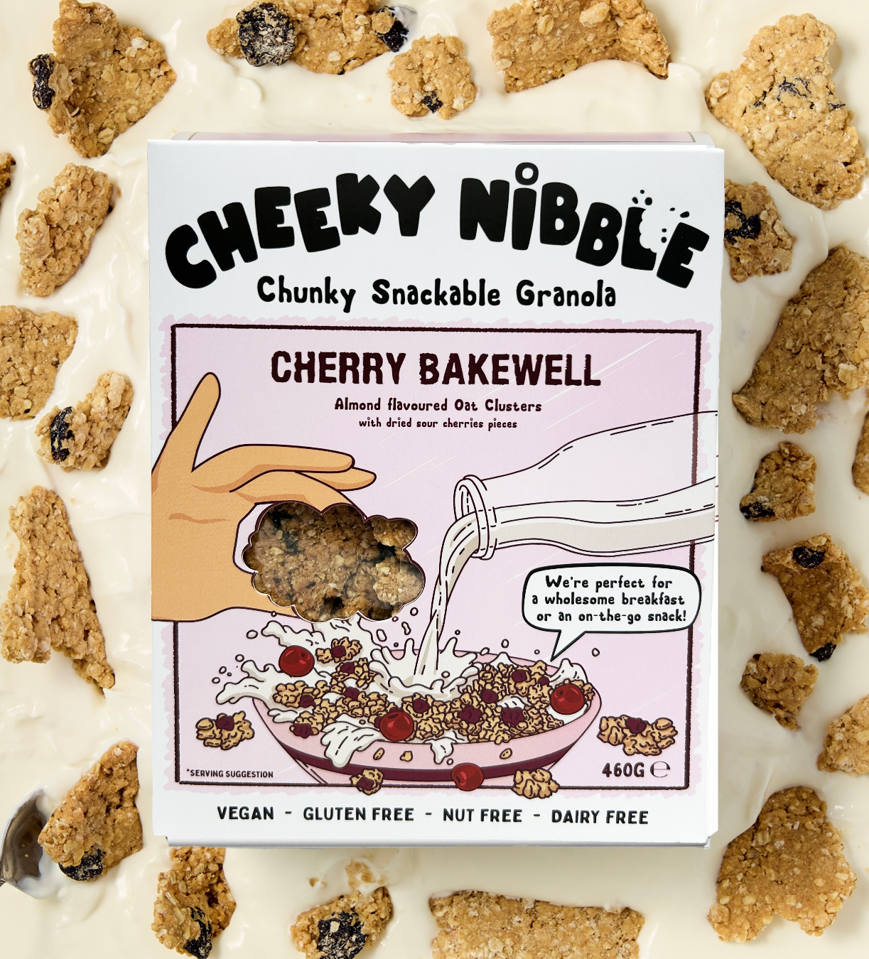 A box of Cherry Bakewell-flavored chunky granola is displayed, showcasing an image of the granola bathed in creamy thick yogurt. The granola features chunks studded with sour cherries, offering a tantalizing blend of tartness and sweetness. The background evokes a sense of indulgence, with hints of almond flourishes and cherry blossoms, enhancing the product's appeal.