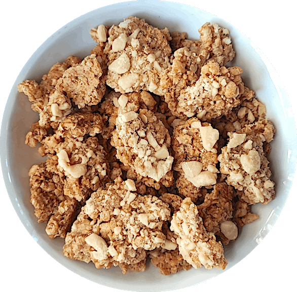 A mouthwatering bowl of Vanilla Latte granola. The granola features large, chunky pieces with a distinct coffee flavor, reminiscent of a delightful vanilla latte. Scattered throughout the mix, you can see creamy vegan white chocolate chips, adding a touch of sweetness to the coffee-infused granola