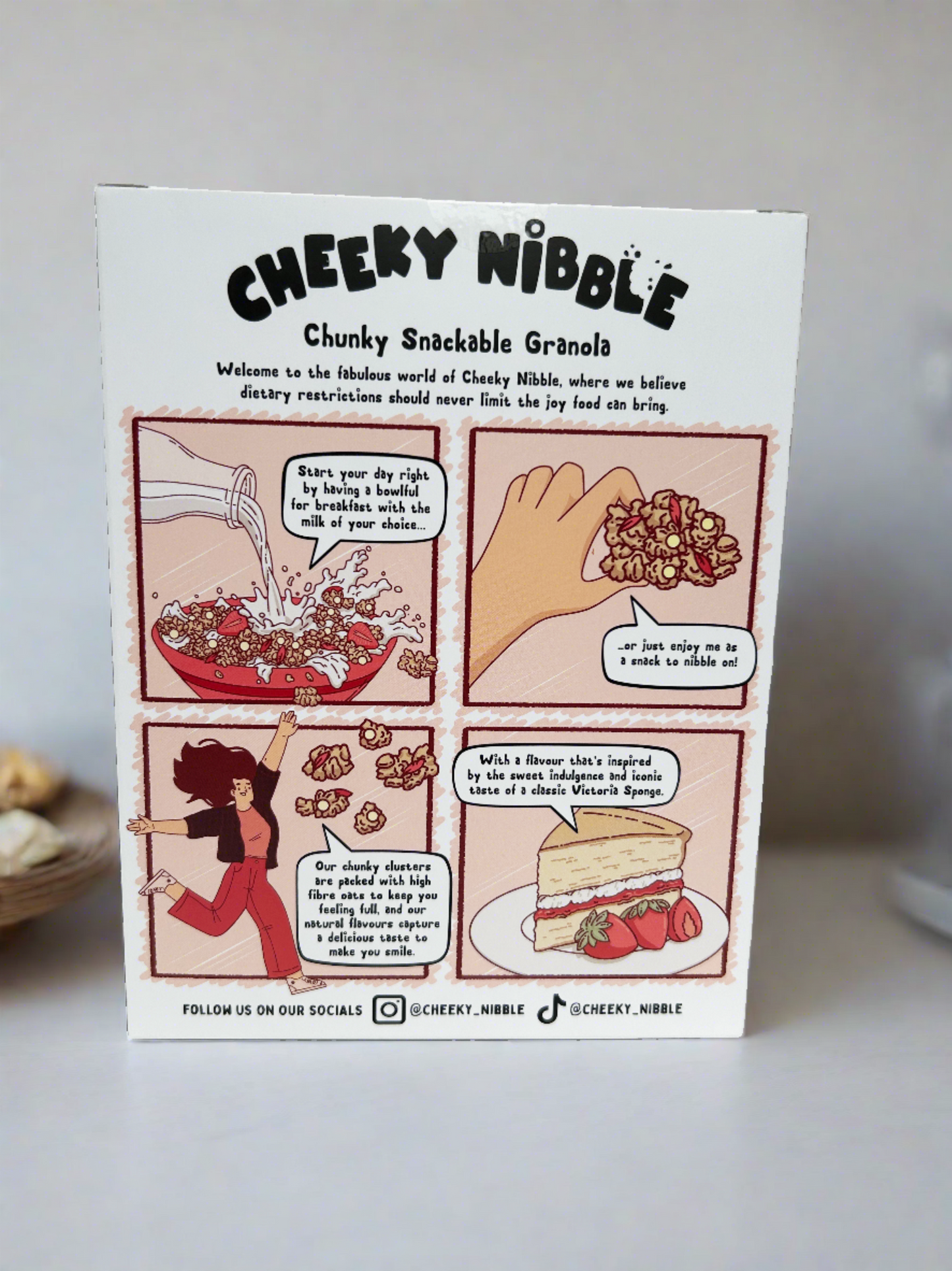 A whimsical cartoon on the back of the granola box depicts a playful scene inspired by the flavor of Victoria Sponge granola. It features a cheerful depiction of a classic British tea party, complete with a tiered cake stand adorned with slices of Victoria Sponge cake. Animated characters, perhaps anthropomorphic fruits or cheerful bakers, interact joyfully around the table, evoking a sense of celebration and indulgence.