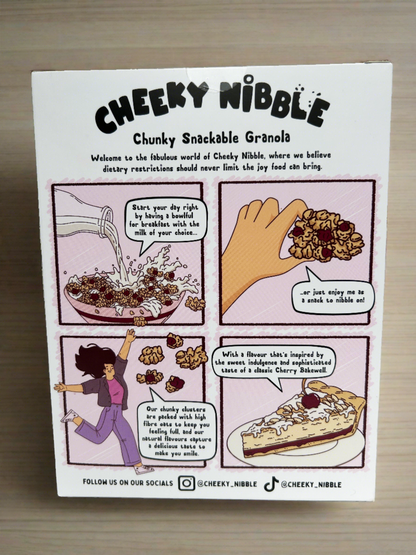 The cartoon on the back of the Cherry Bakewell Granola box depicts a delightful scene reminiscent of a bustling bakery. A cheerful baker is shown skillfully crafting a batch of Cherry Bakewell Granola, surrounded by whimsical cherry trees laden with ripe fruit. The aroma of almonds and cherries fills the air, evoking a sense of warmth and nostalgia. The scene exudes a cozy, inviting atmosphere, promising consumers a taste of homemade goodness and sweet indulgence.