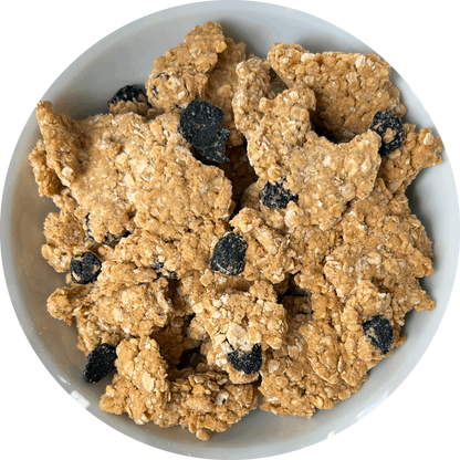 Image: A tempting bowl of Cherry Bakewell granola. The granola features large, chunky almond-flavored pieces that promise a satisfying crunch. Scattered throughout the mix, you can see tangy, sour dried cherries, adding a burst of fruity sweetness. The granola is reminiscent of the classic Cherry Bakewell dessert, with the delightful combination of almond and cherry flavors. 