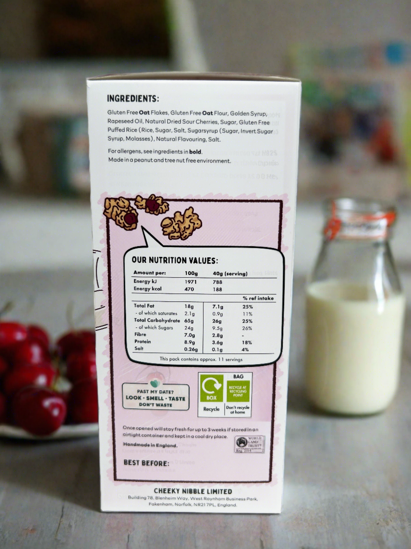 Alt text: A cereal box with a prominent display of nutritional information for Cherry Bakewell flavored granola. The label features details such as serving size, calorie count, macronutrient breakdown (including protein, fat, and carbohydrates), and essential vitamins and minerals. The text is legible and clear, providing consumers with essential dietary information to make informed choices.