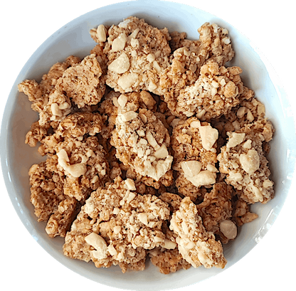 A mouthwatering bowl of Vanilla Latte granola. The granola features large, chunky pieces with a distinct coffee flavor, reminiscent of a delightful vanilla latte. Scattered throughout the mix, you can see creamy vegan white chocolate chips, adding a touch of sweetness to the coffee-infused granola