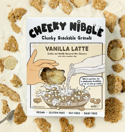  A box of Vanilla Latte-flavored chunky granola is depicted, featuring an enticing image of the granola bathed in creamy thick yogurt. The granola chunks are generously coated with white chocolate, vanilla, and coffee flavors, creating a visually appealing breakfast or snack option. The background suggests a cozy café setting, with hints of coffee beans and swirling latte art, enhancing the sensory experience.